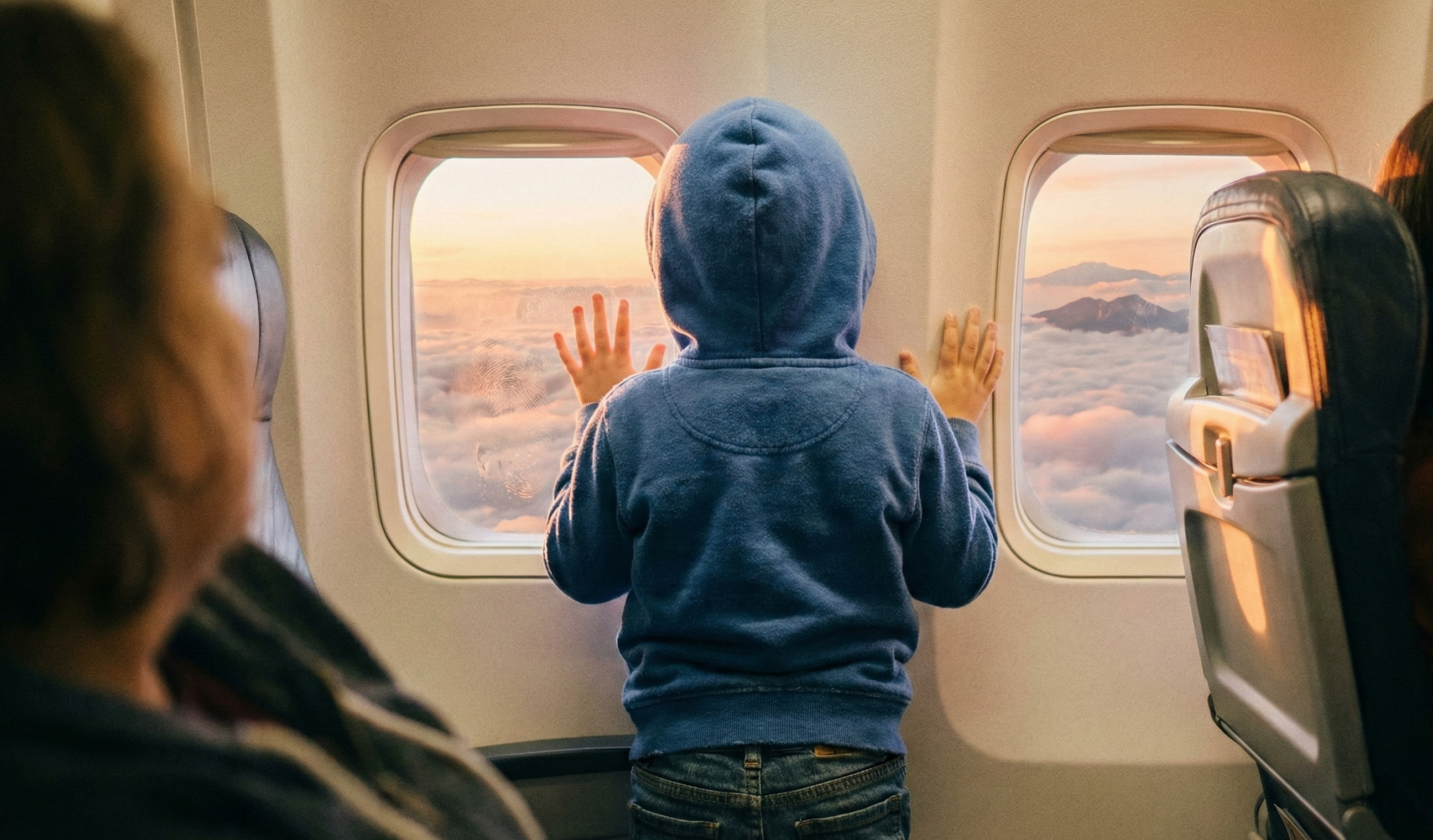 飛行機の窓から外を見ている子供の後ろ姿